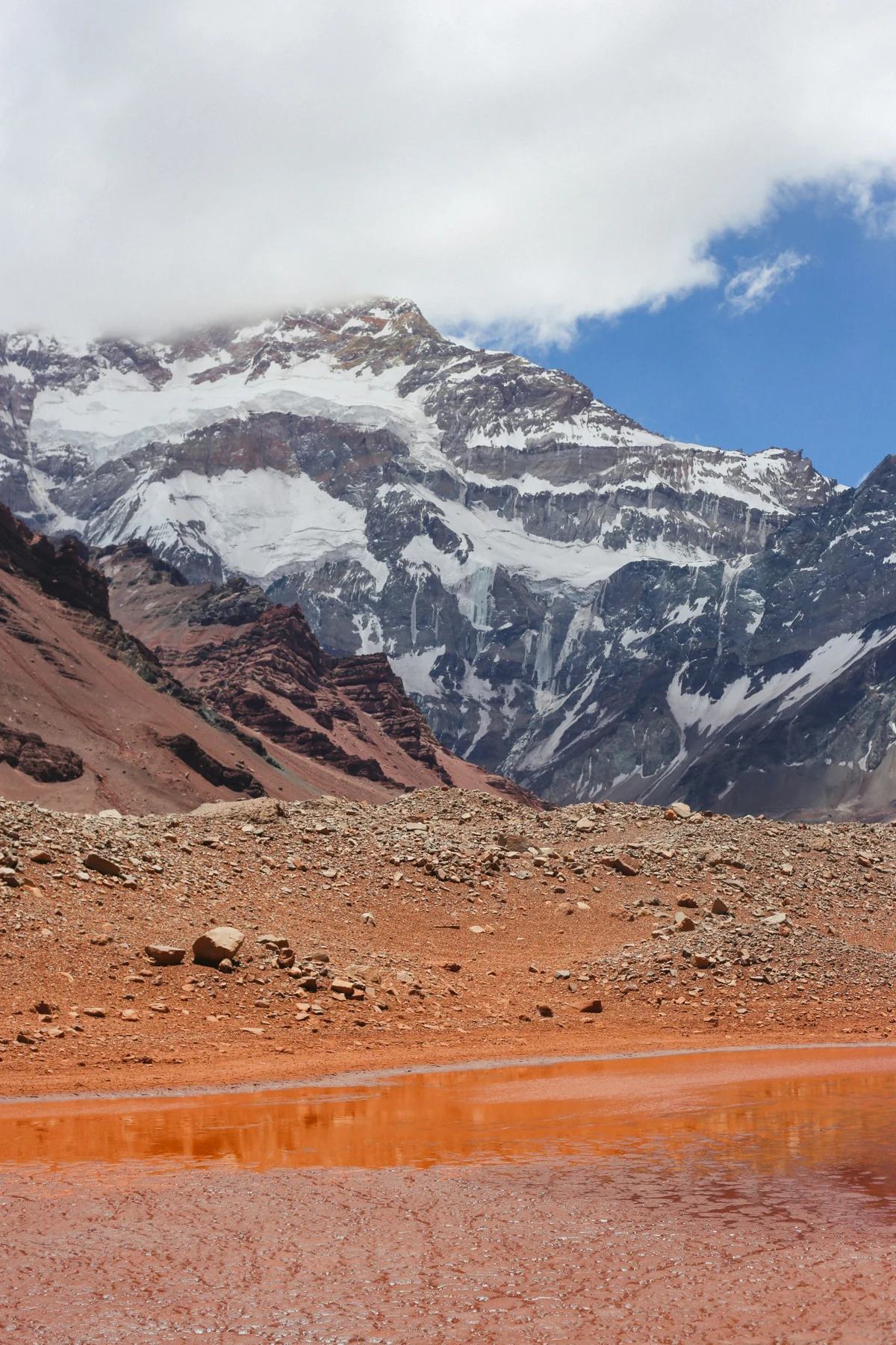 El Aconcagua nevado sobre un paisaje de tierra rojiza